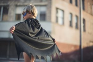 little boy with black mask and superhero cape