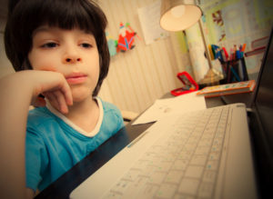 child browsing the internet on a laptop computer