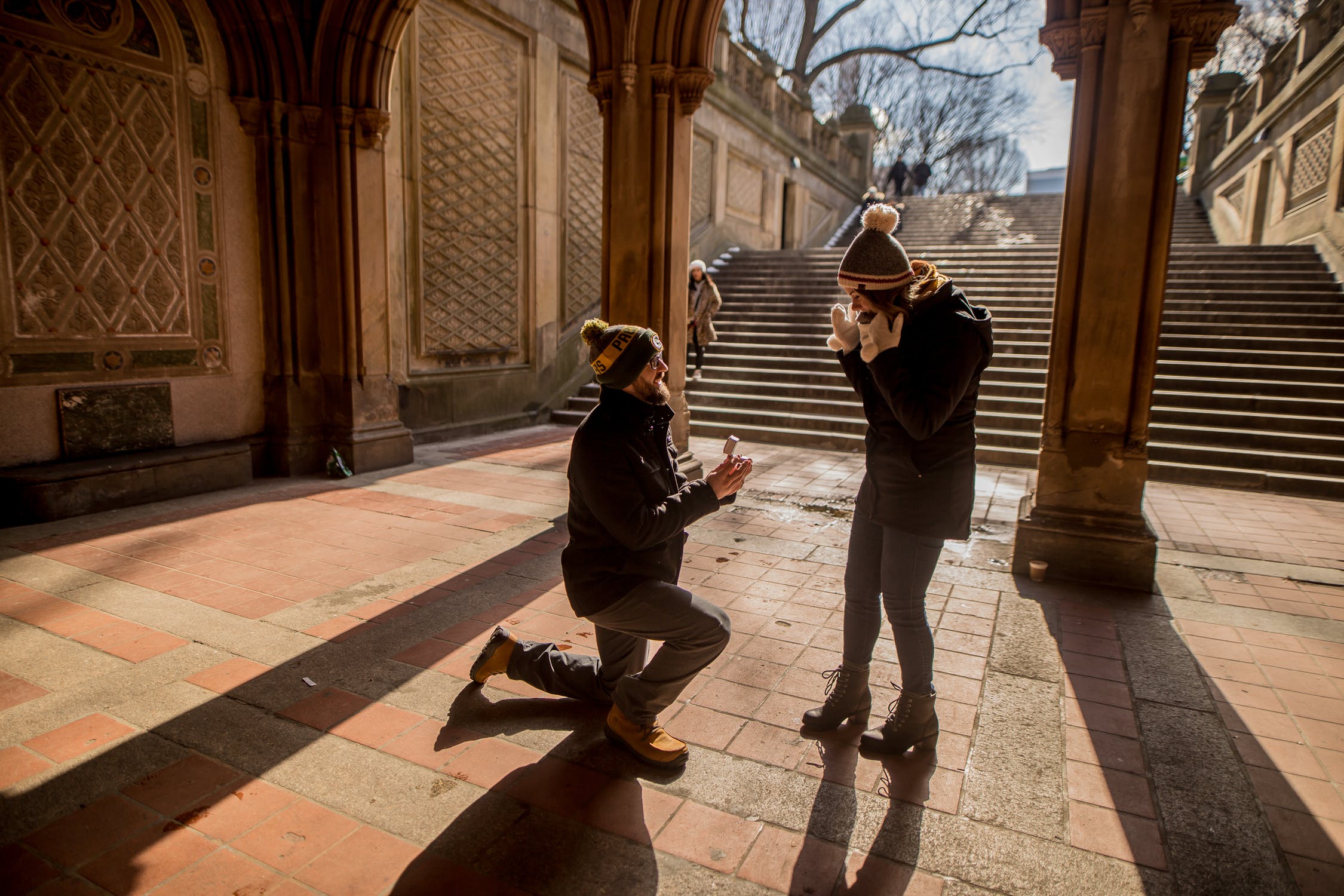 man down on one knee outside proposing to woman