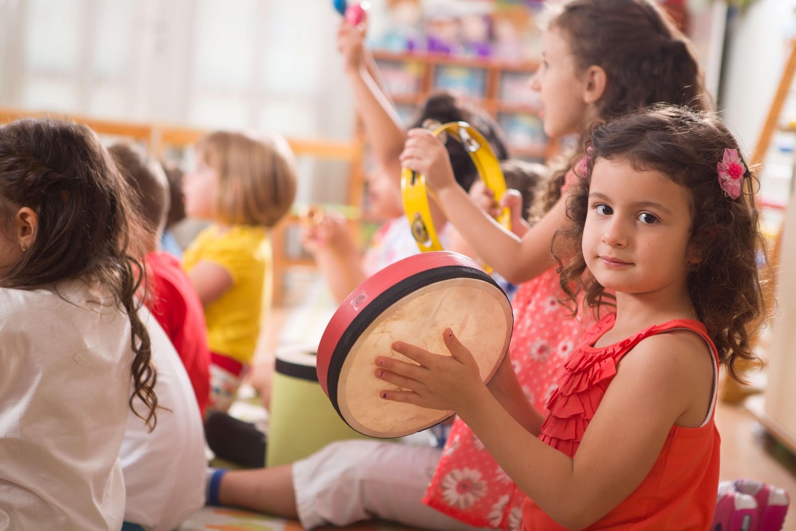 Young children playing instruments while seated in a class