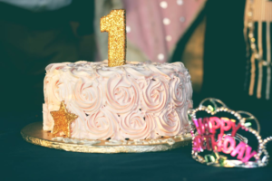 birthday cake with golden 1 on top of it with birthday tiara sitting next to it